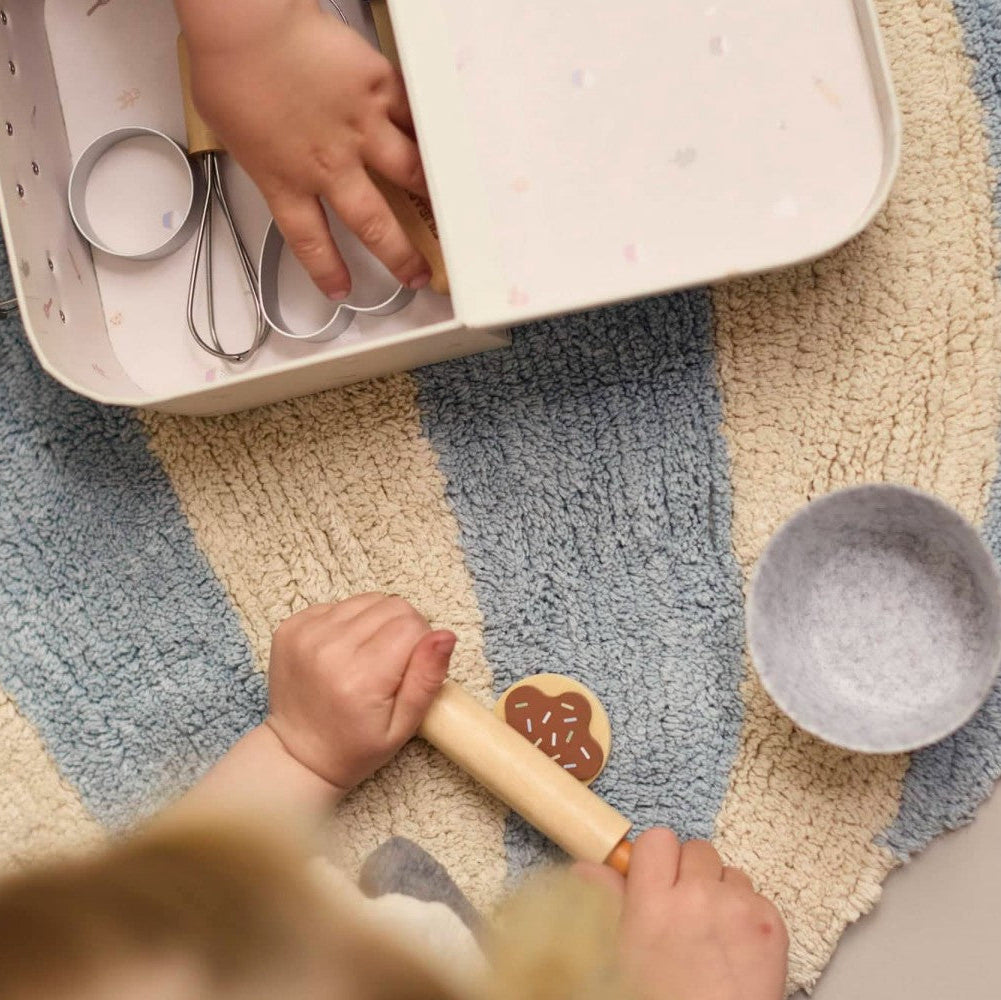 Child playing with kitchen toys on a colorful rug