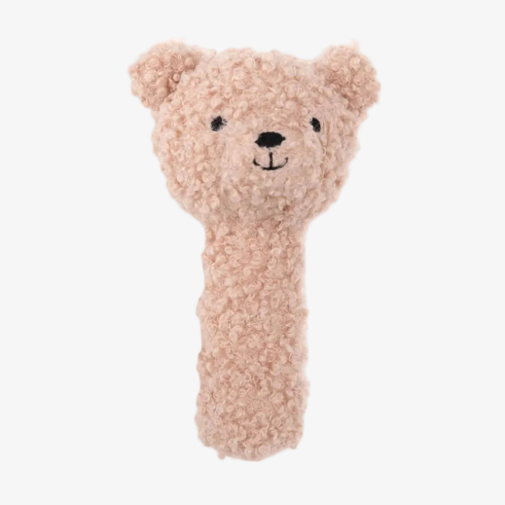 Plush teddy bear rattle in pink color on a white background