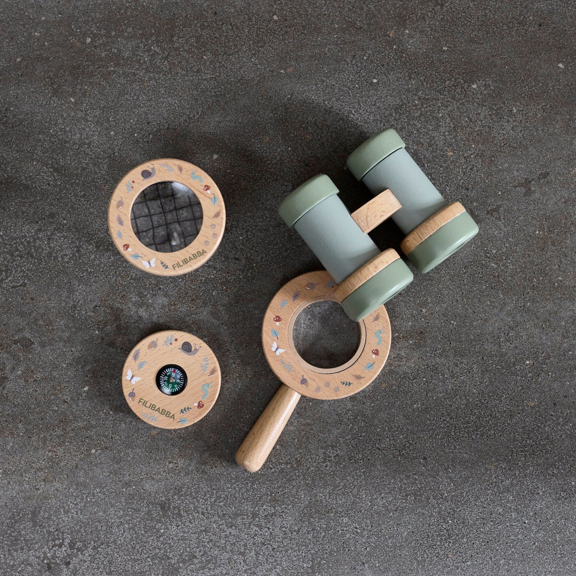 Wooden baby rattle with green accents on a dark surface