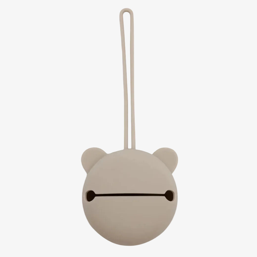Round beige object with a string, resembling a bear's face, on a white background