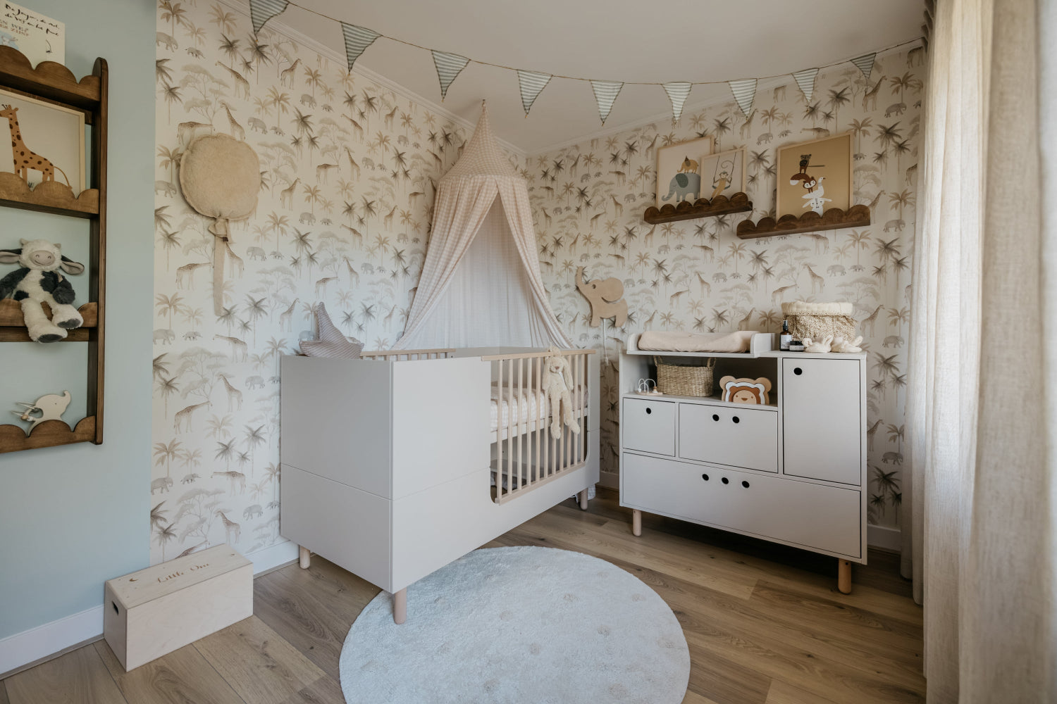 Nursery room with white crib, shelves, and decorative elements on a floral wallpapered wall.