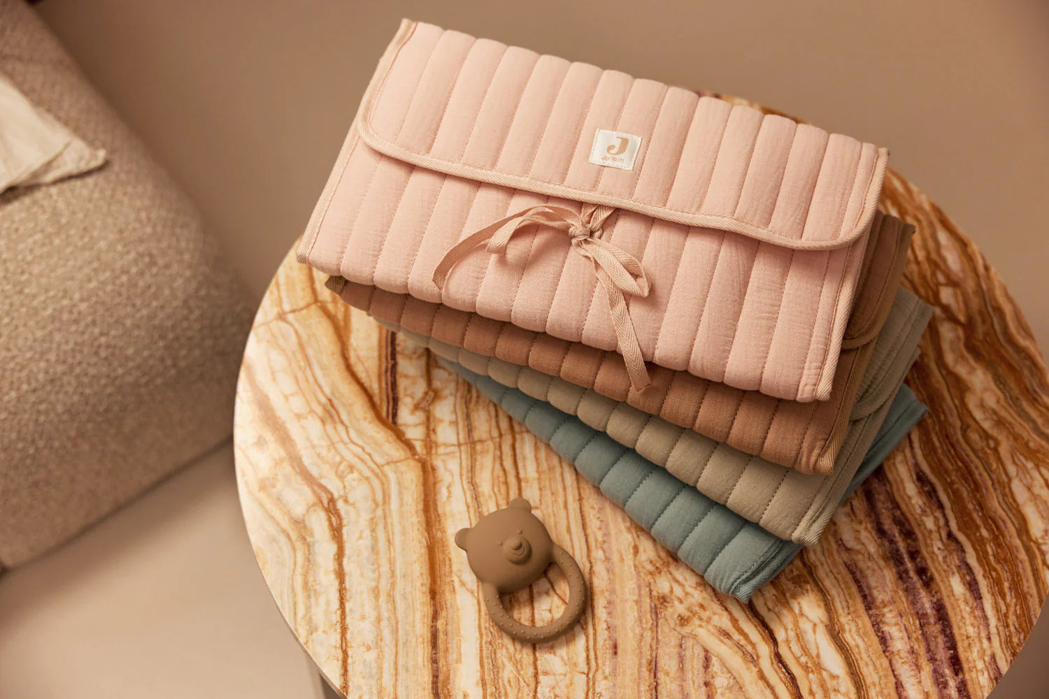 Stack of quilted bags in various colors on a wooden surface