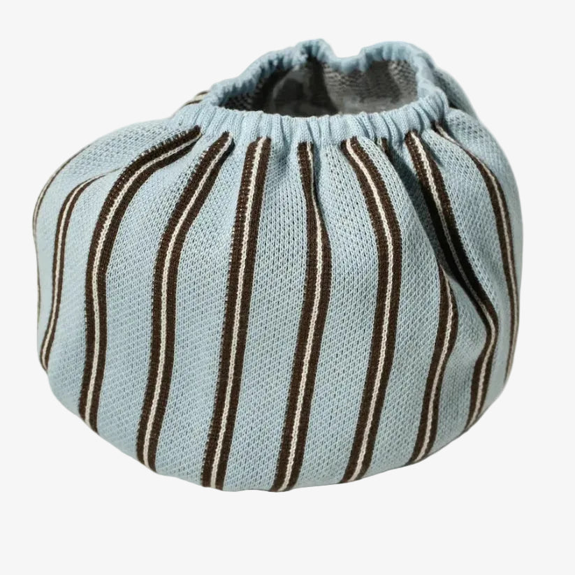 A light blue knit pouch bag with vertical brown and white stripes, featuring a gathered elastic top, photographed on a neutral light gray background.