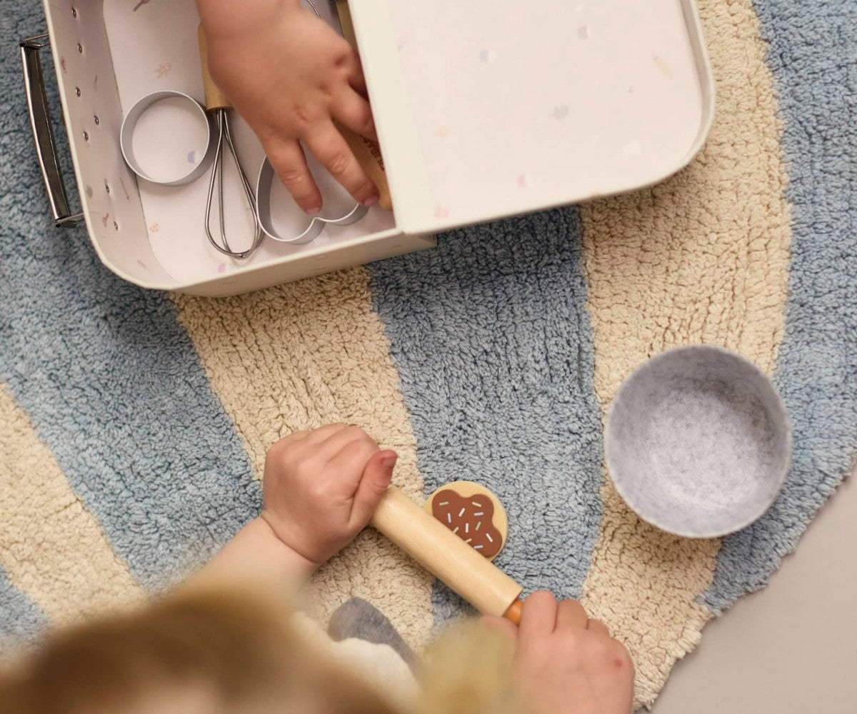 Child playing with kitchen toys on a colorful rug