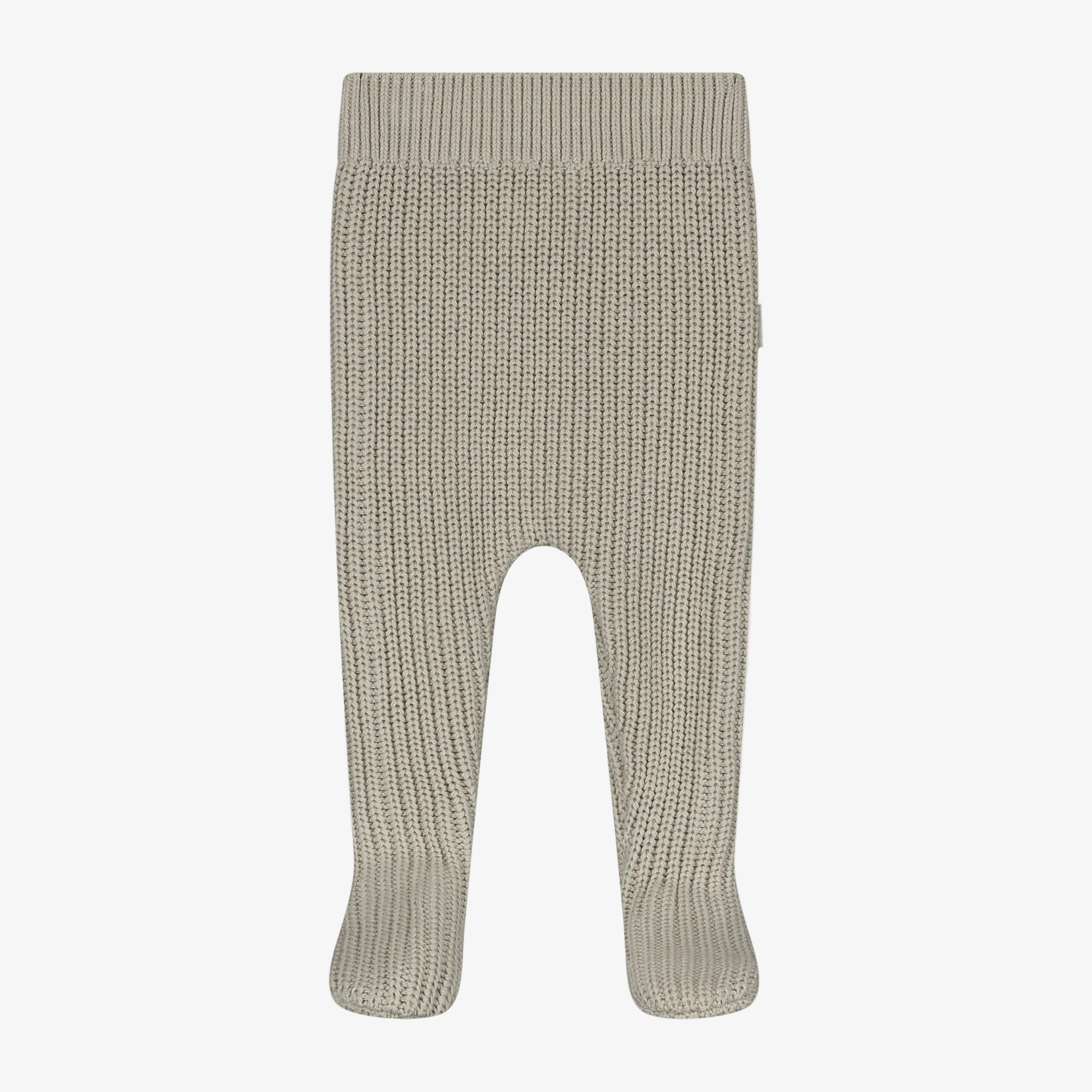 A pair of ribbed knit baby booties in a light oatmeal beige color, shown flat against a neutral light gray background.