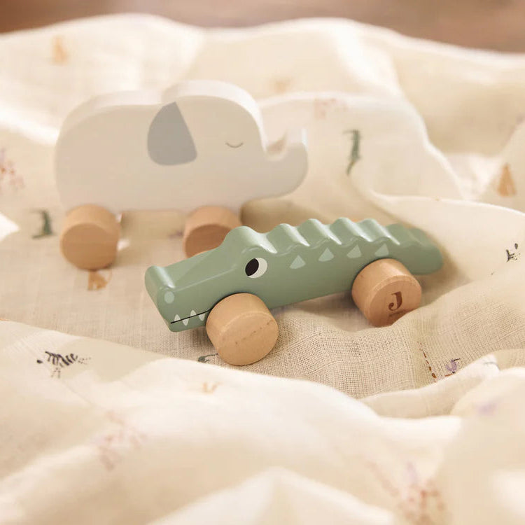 Wooden toy car and elephant on a soft fabric surface