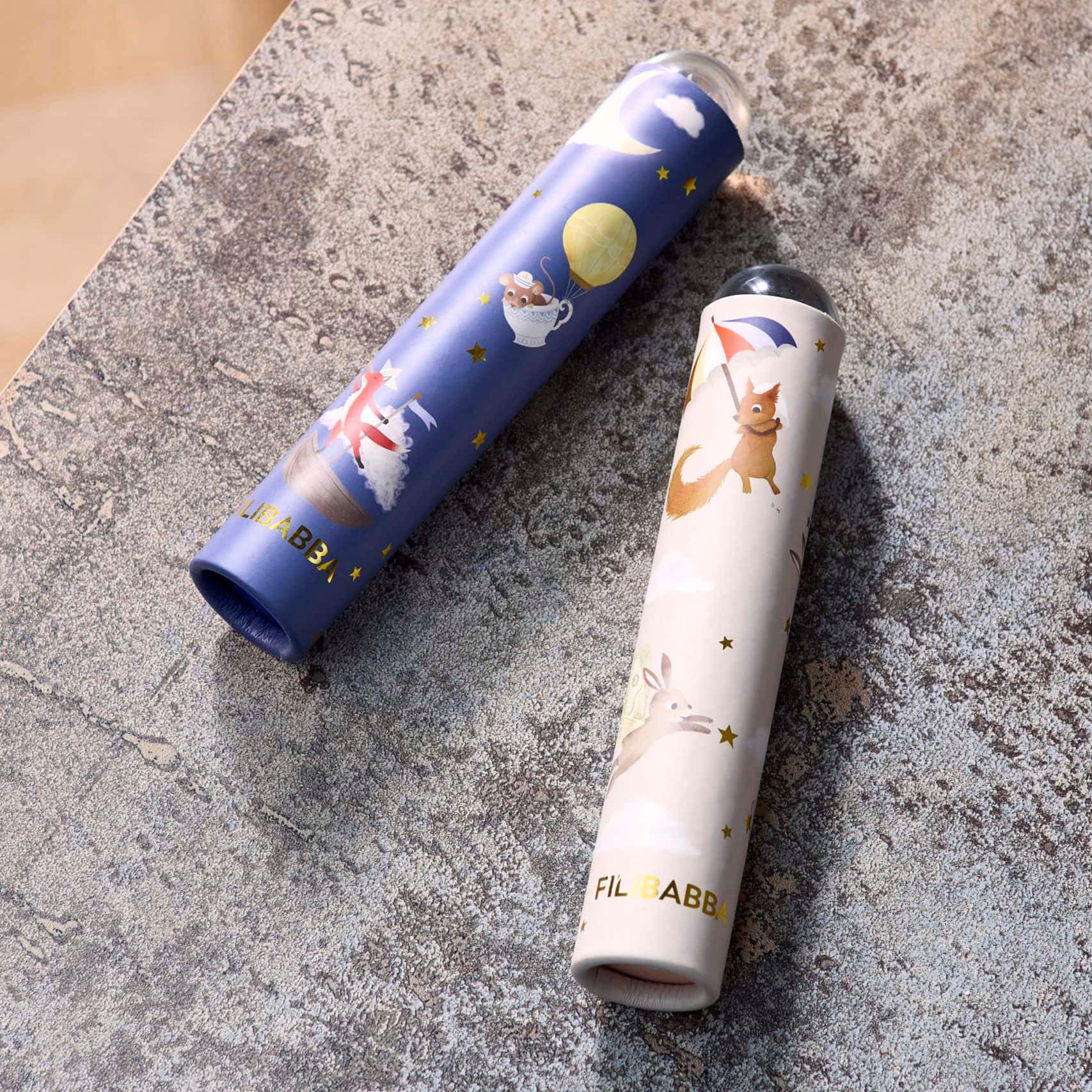 Two cylindrical products with cartoon designs on a textured surface
