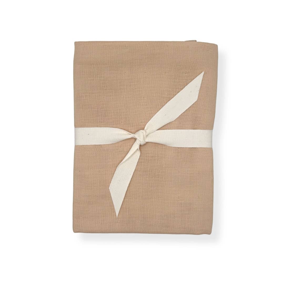 Folded beige fabric with a white ribbon on a white background
