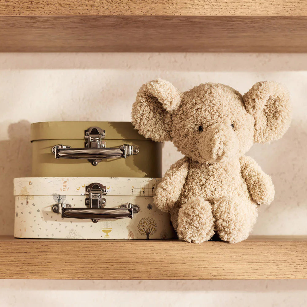 Teddy bear and vintage suitcases on a wooden shelf