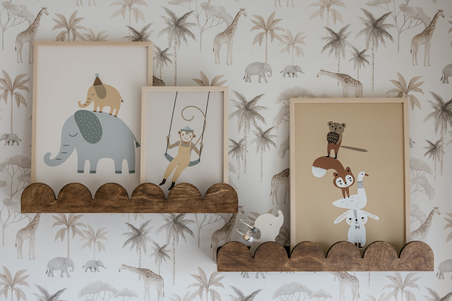 Three framed illustrations of animals on a wooden shelf against a wallpapered wall with animal patterns.